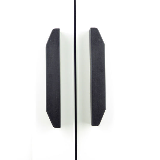 A pair of black tapered wooden handles installed on a white wardrobe.