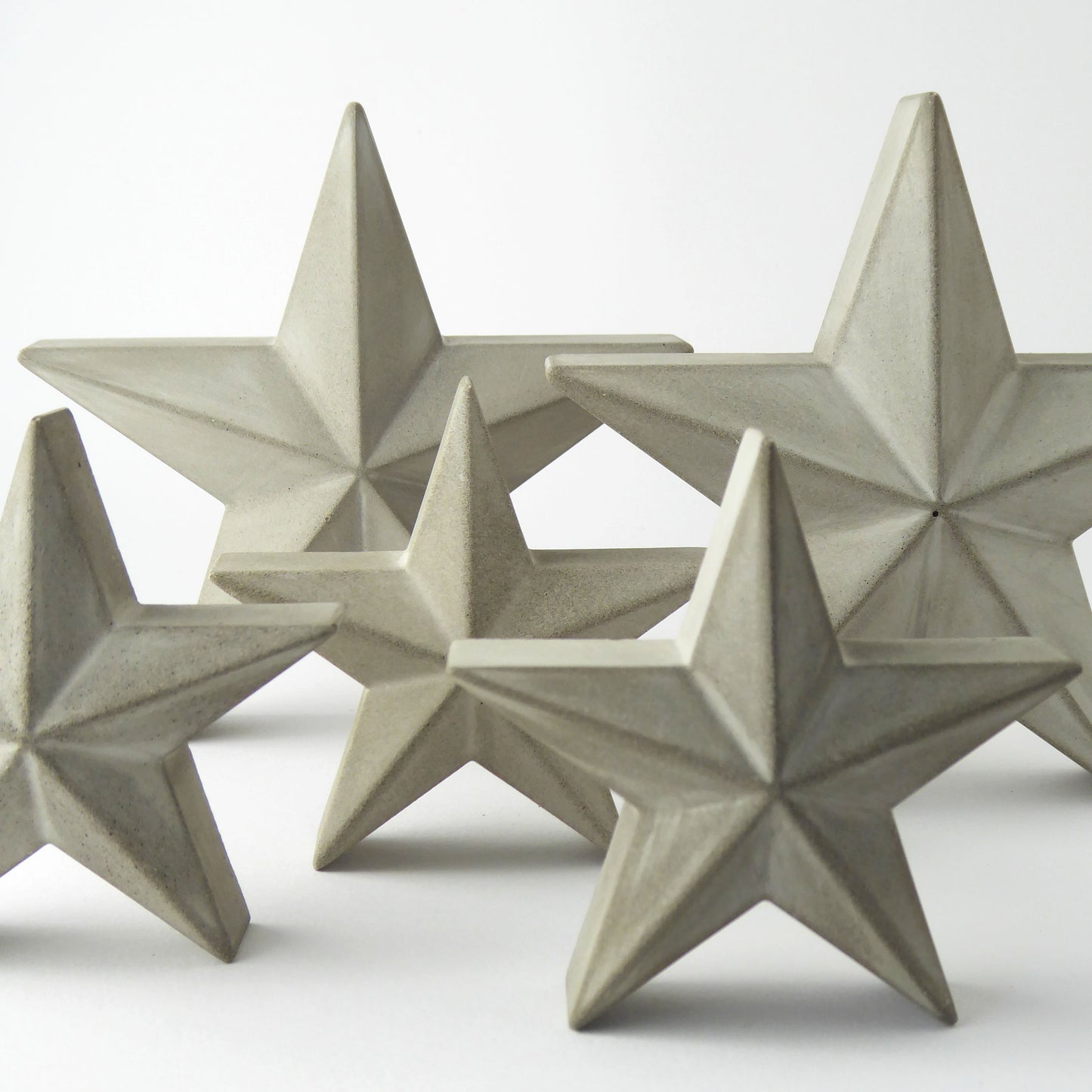 Set of five star-shaped decorative freestanding ornaments on a white background