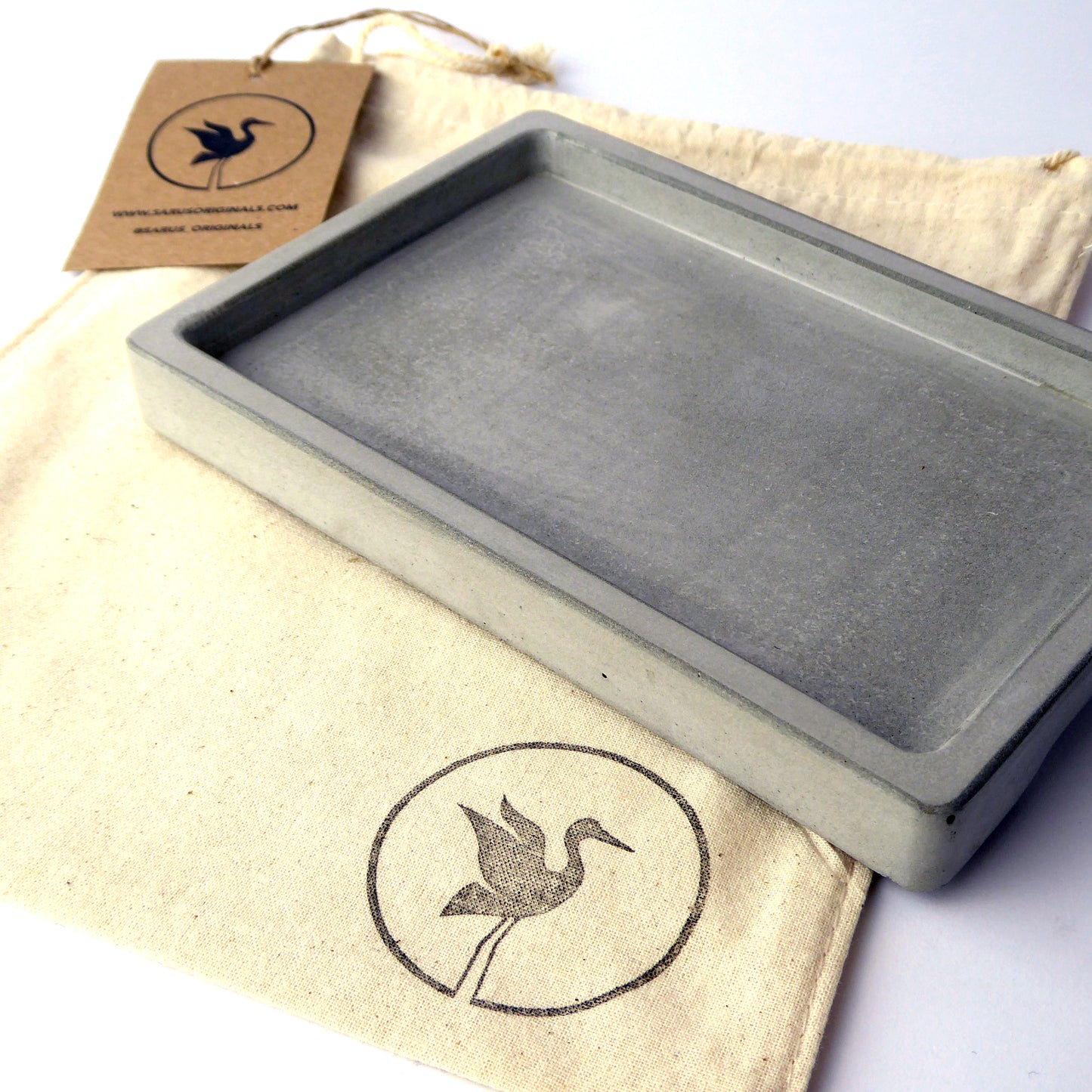 Grey concrete valet tray with a branded gift bag