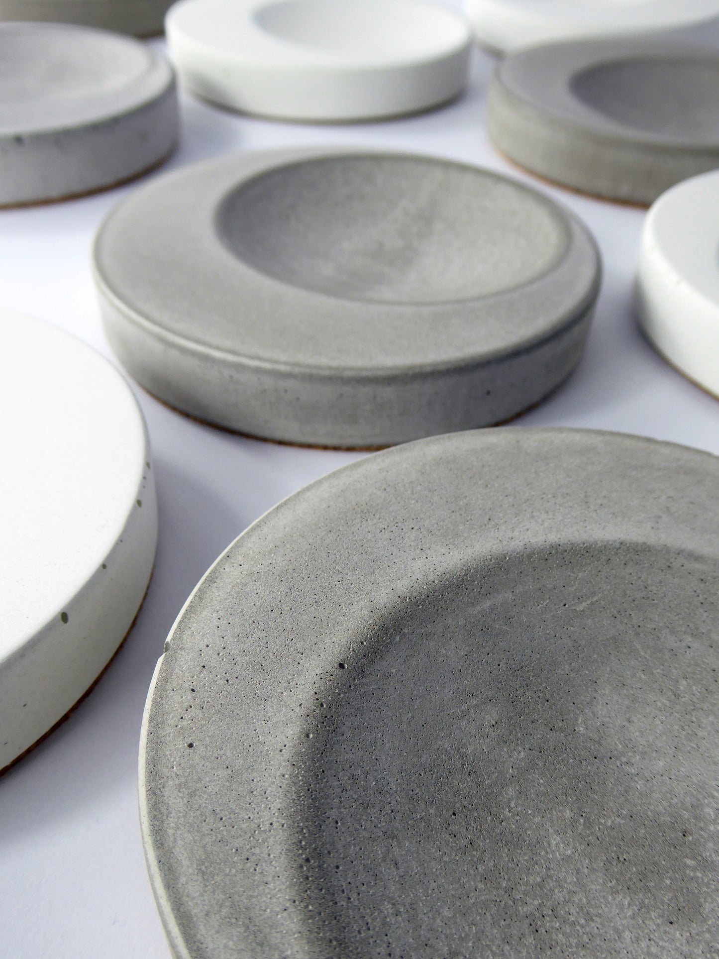 Grey and white round concrete trinket trays on a white background
