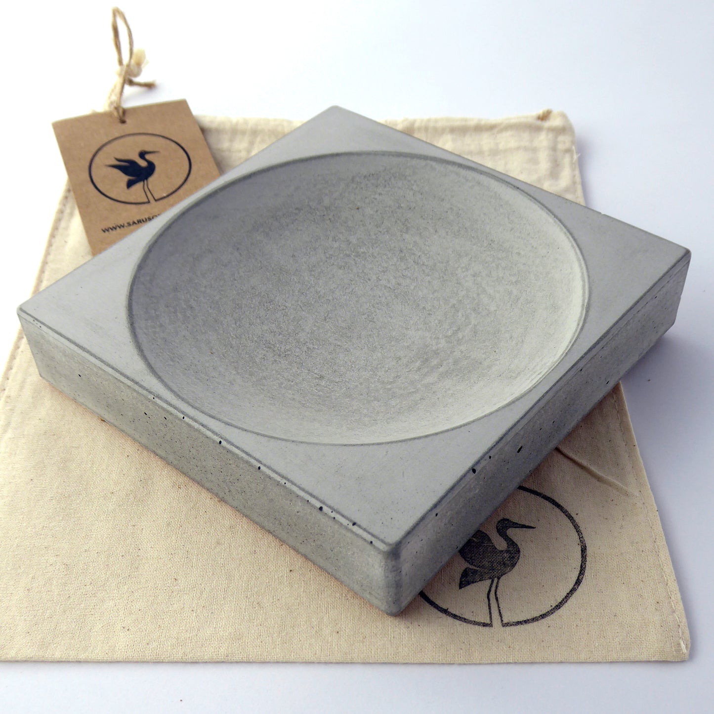 Square concrete bowl on a gift bag with branded tag