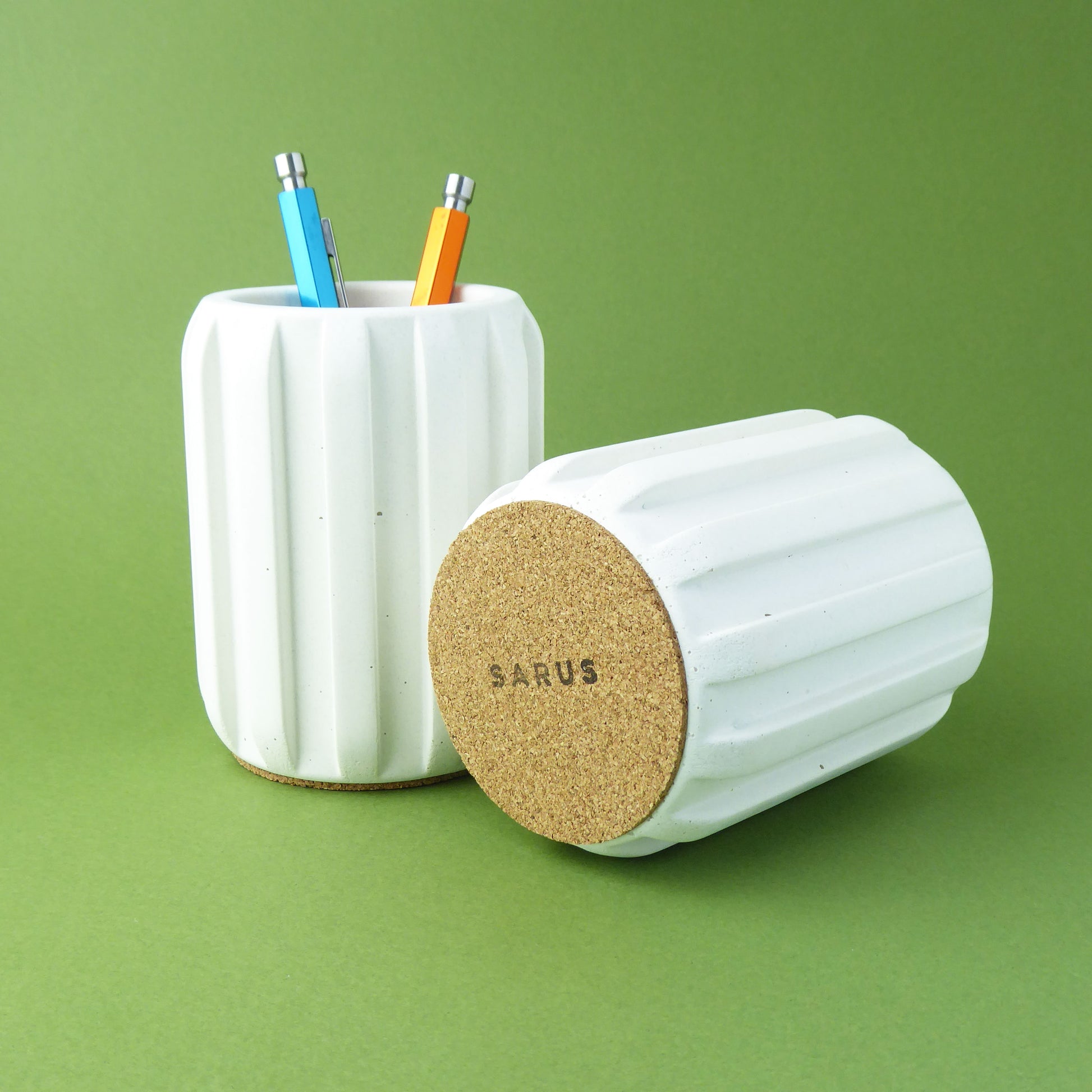 White ribbed pencil holder with cork base on a green background
