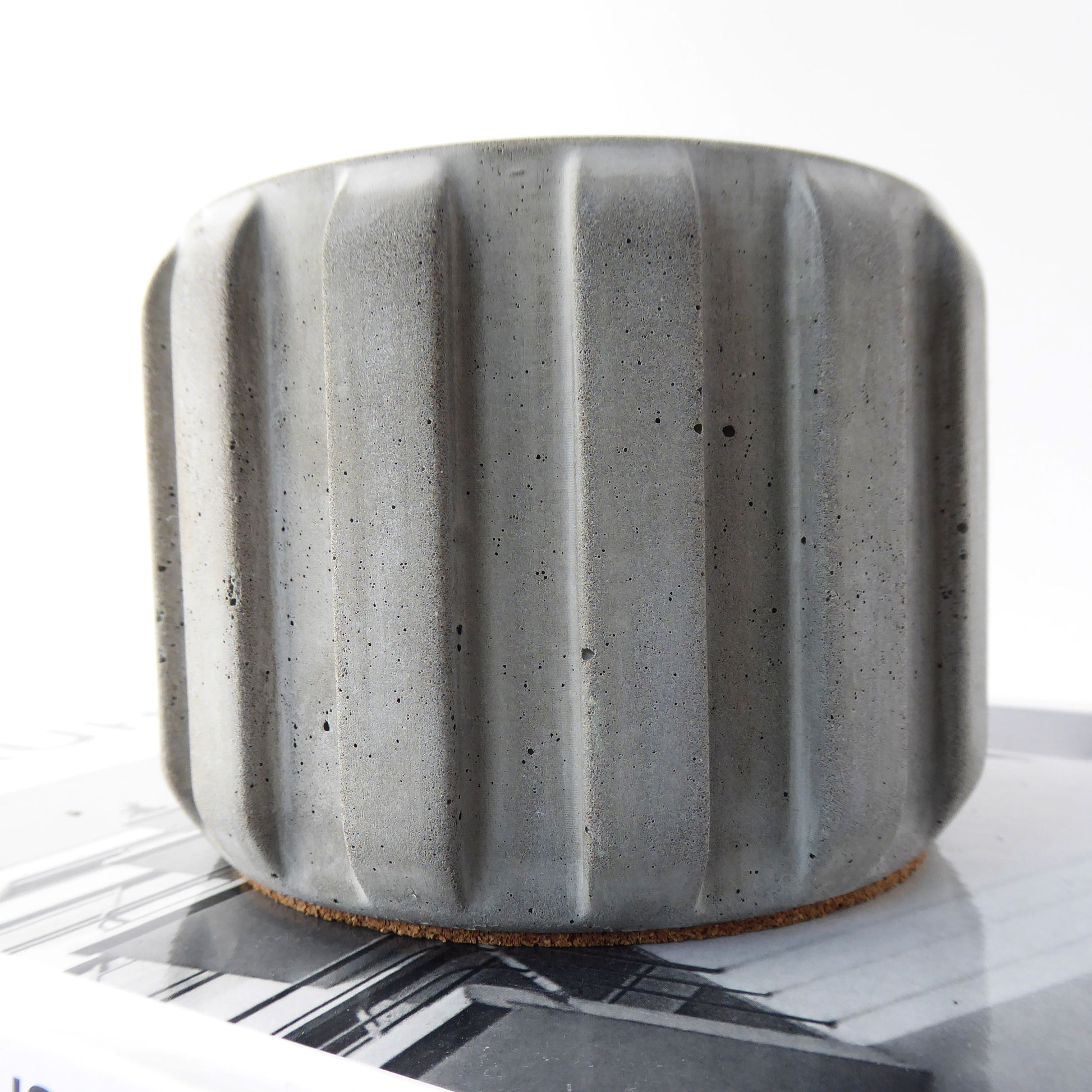 Raw grey concrete textured planter with a ribbed design