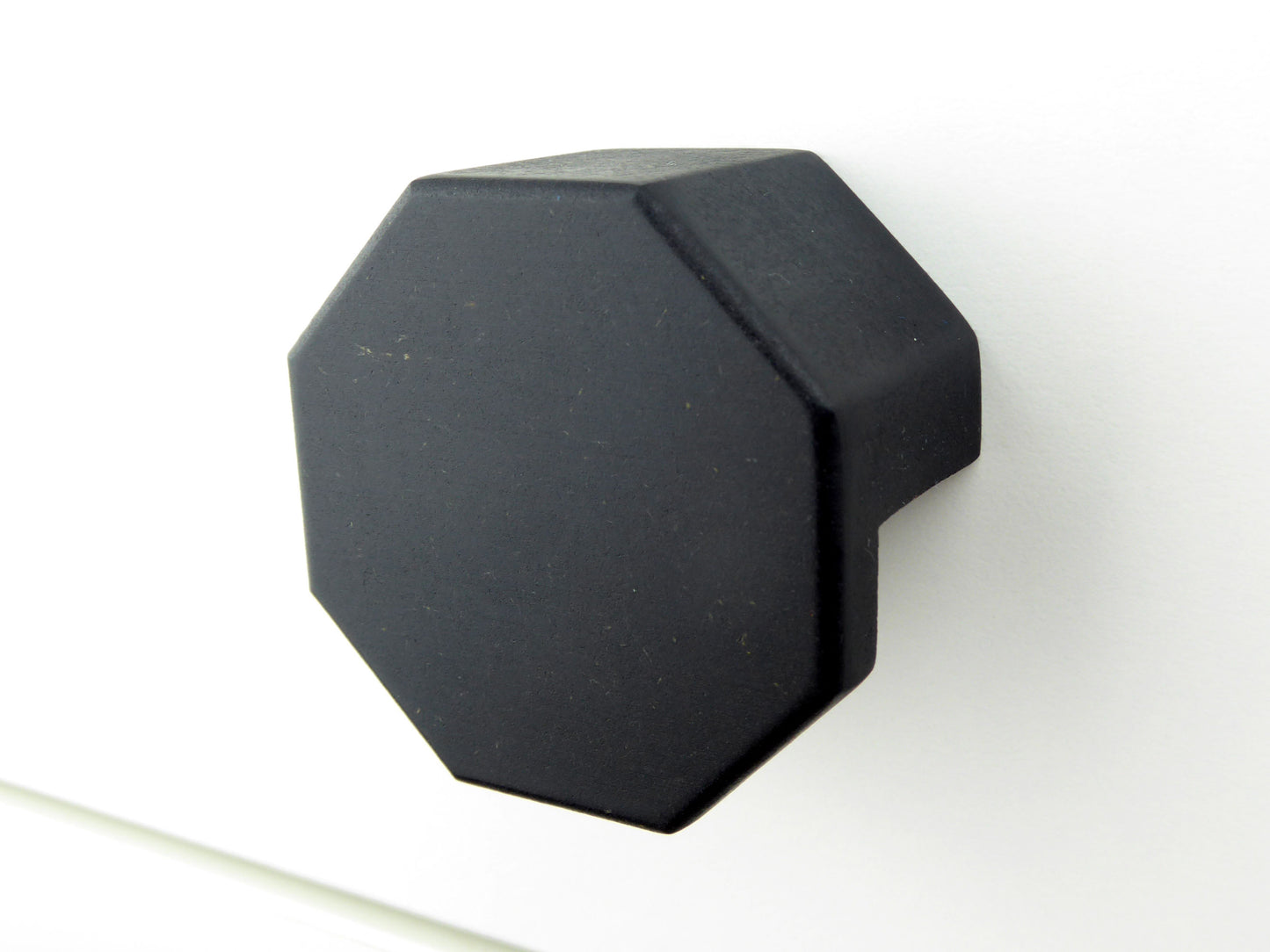 Modern black drawer handle with a hexagon shape crafted from wood