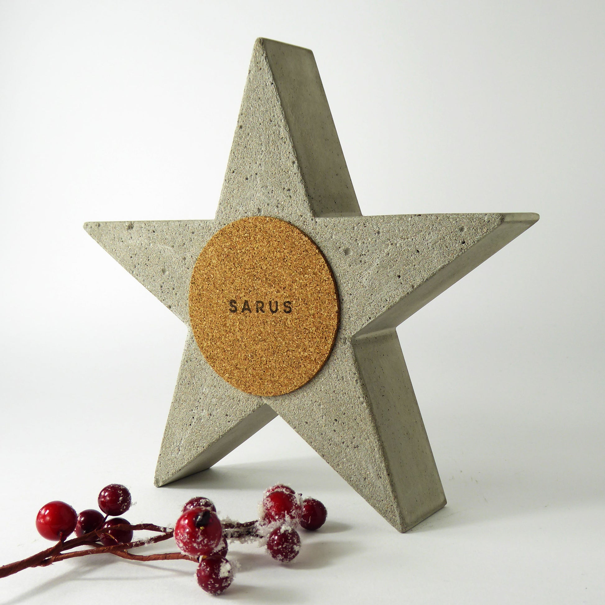 Concrete star with cork back with the 'SARUS' logo on a white background