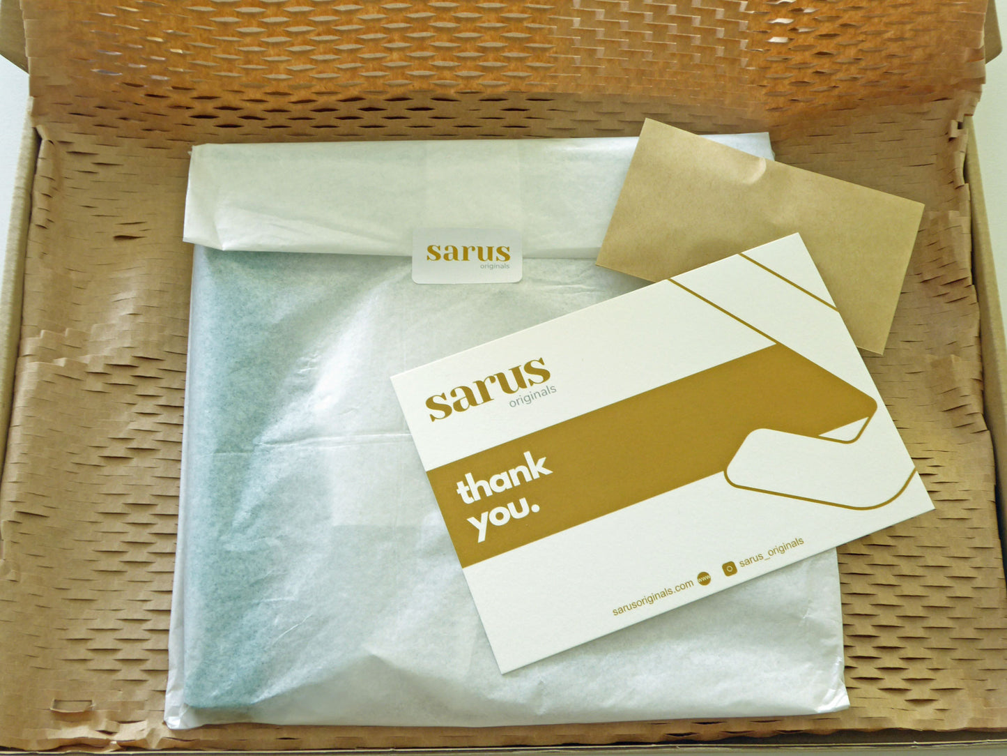 Box with a tissue-wrapped package and a thank you note