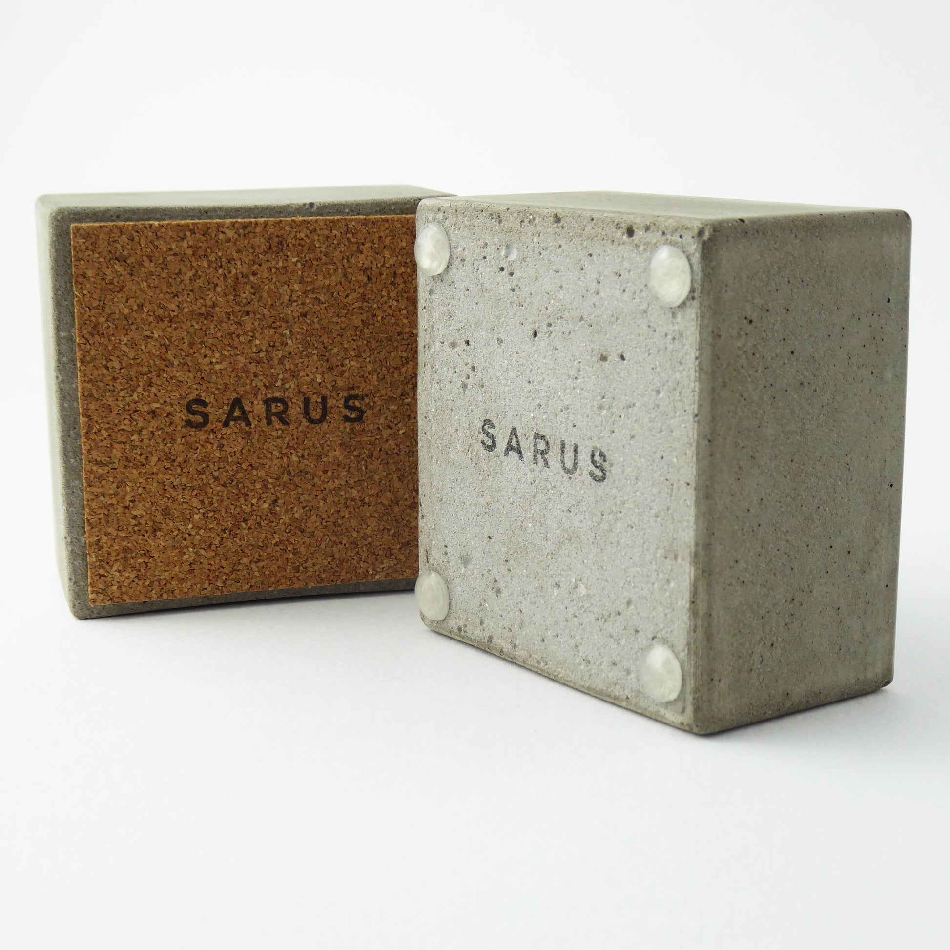 Two concrete bowls with cork base and rubber feet.