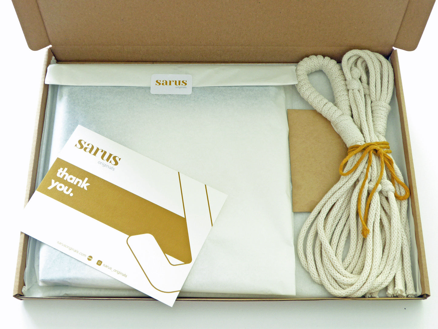 Gift box with a tissue wrapped plant hook and a handcrafted macrame hanger together with a thank you note