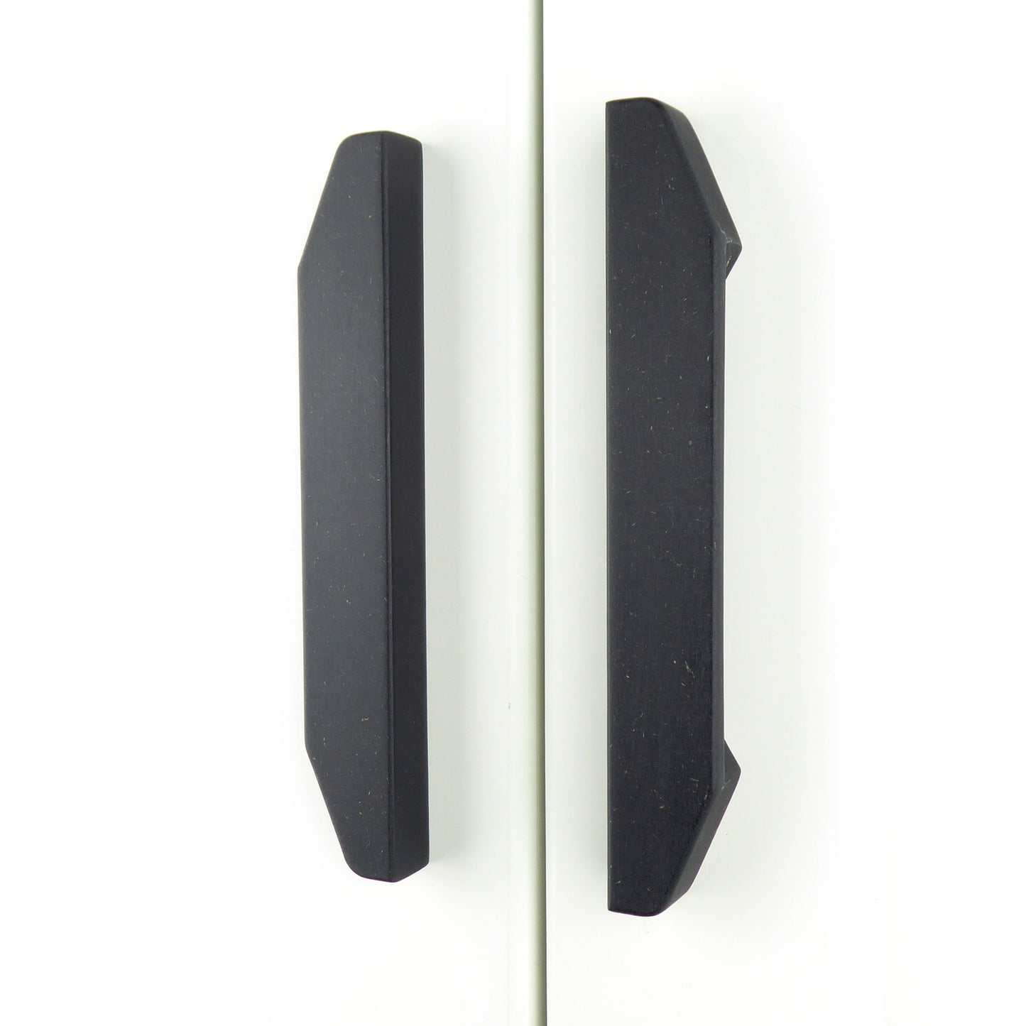 A pair of matt black long wardrobe handles crafted from eco-friendly Valchromat wood