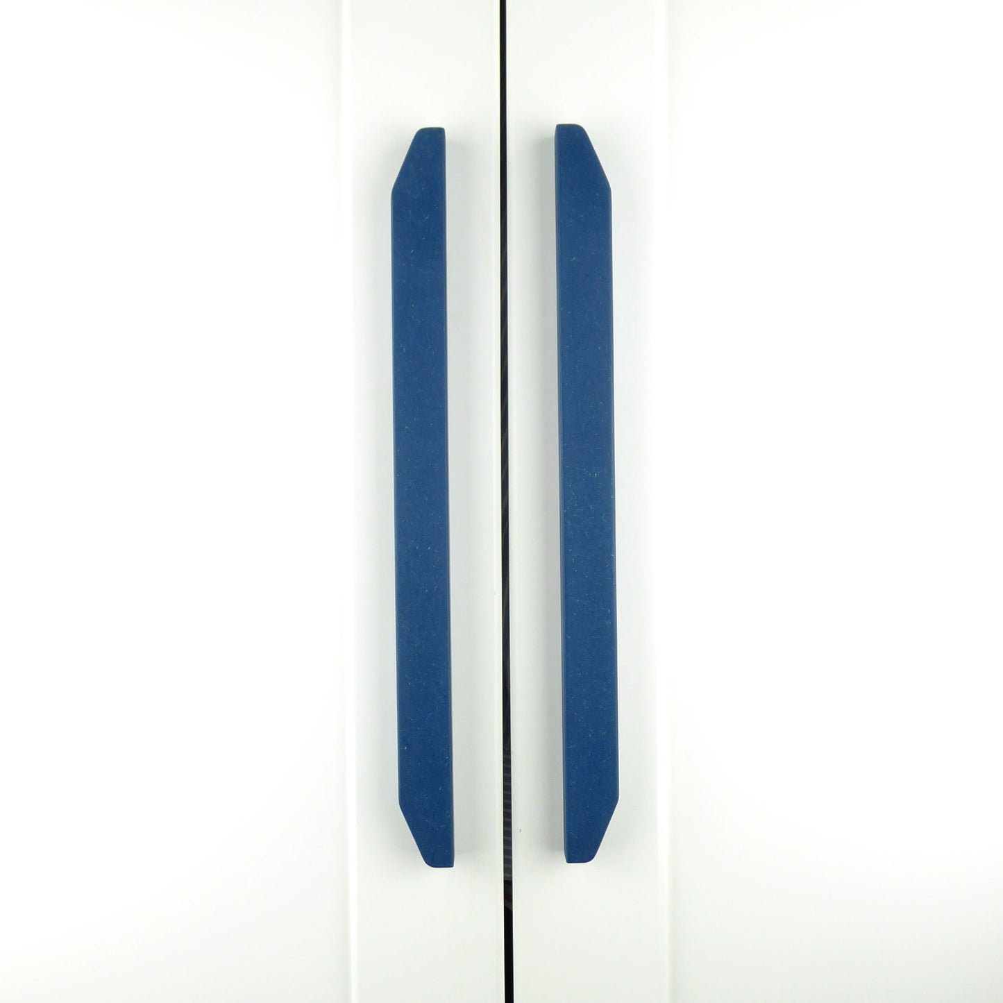 A pair of striking handcrafted wooden wardrobe handles in blue colour, installed on a white wardrobe.