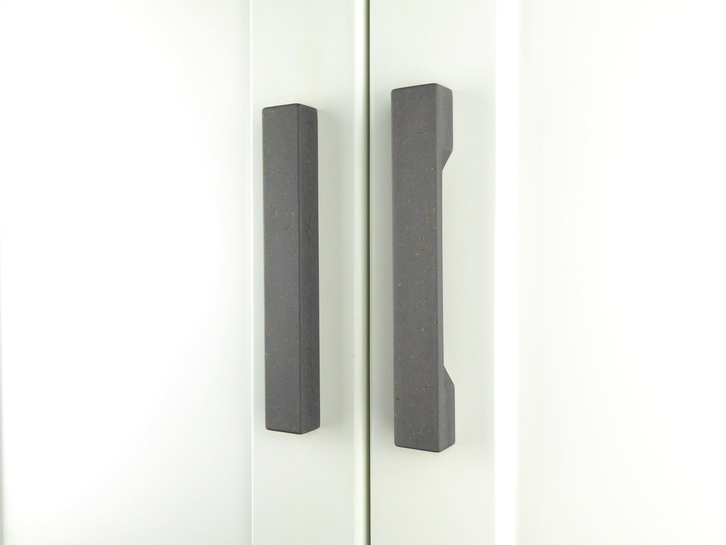 Pair of grey handmade kitchen door handles on a white wooden door