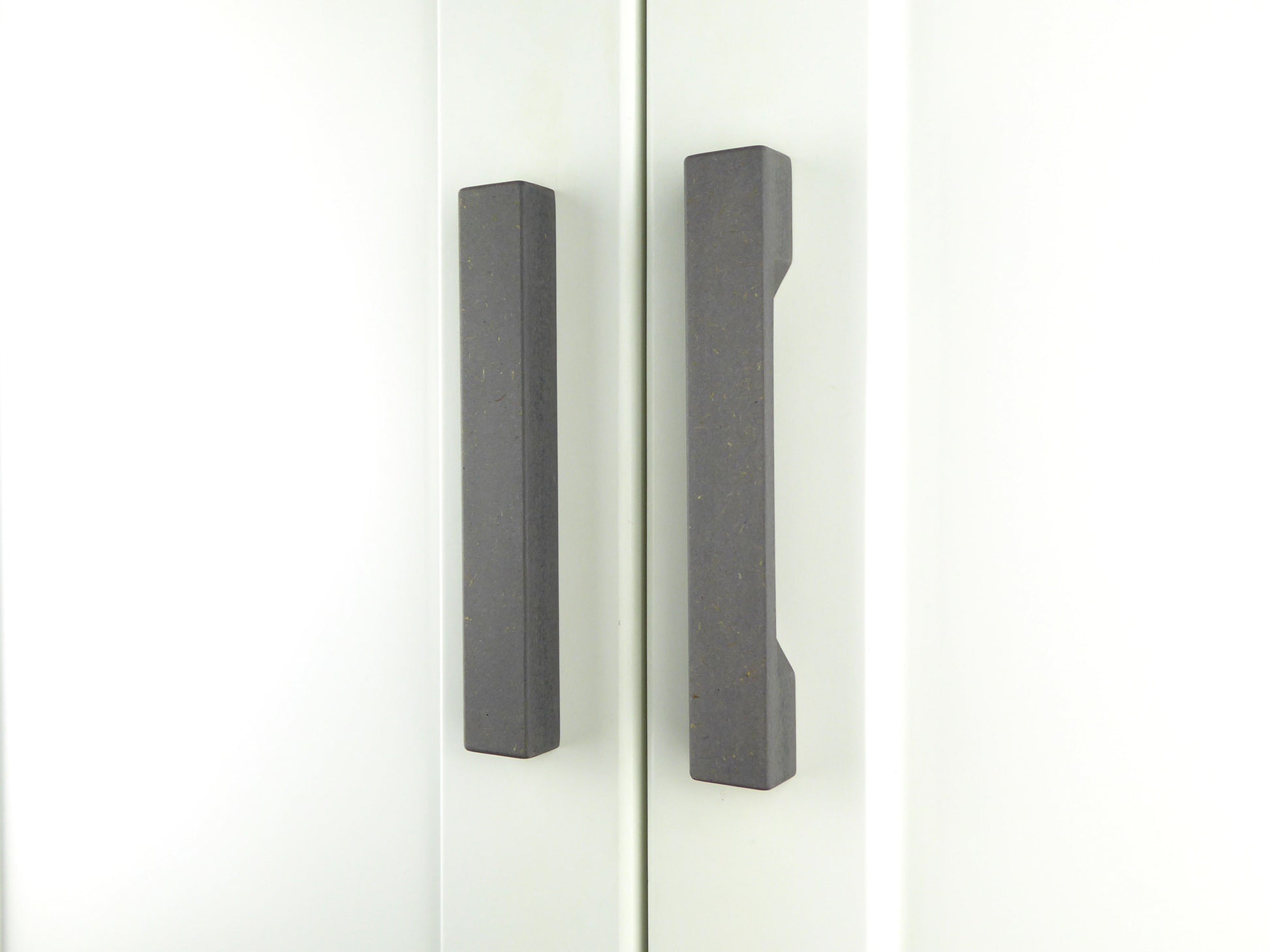 Pair of grey handmade kitchen door handles on a white wooden door
