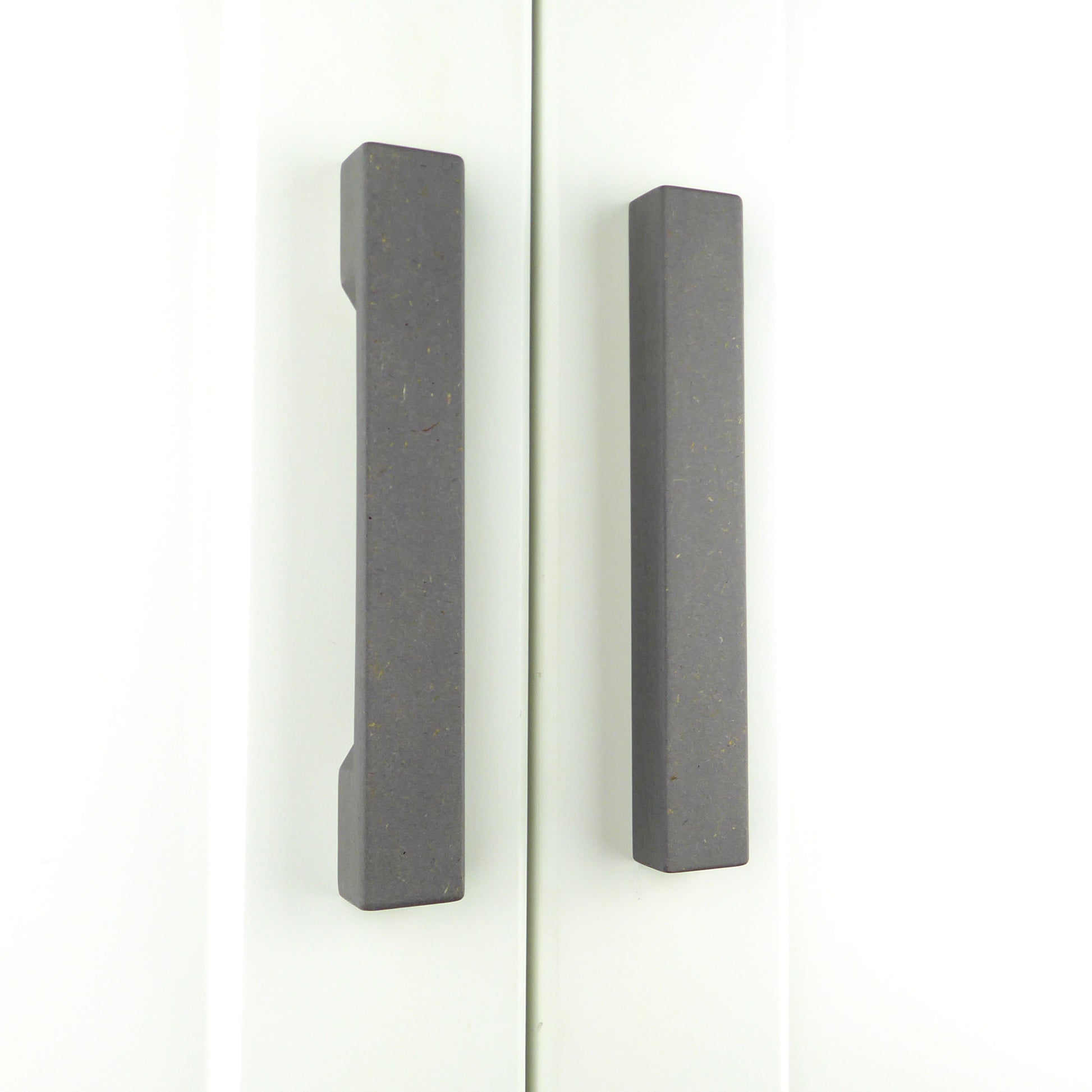 Two slimline wooden wardrobe handles in grey colour, mounted vertically on a white wardrobe.
