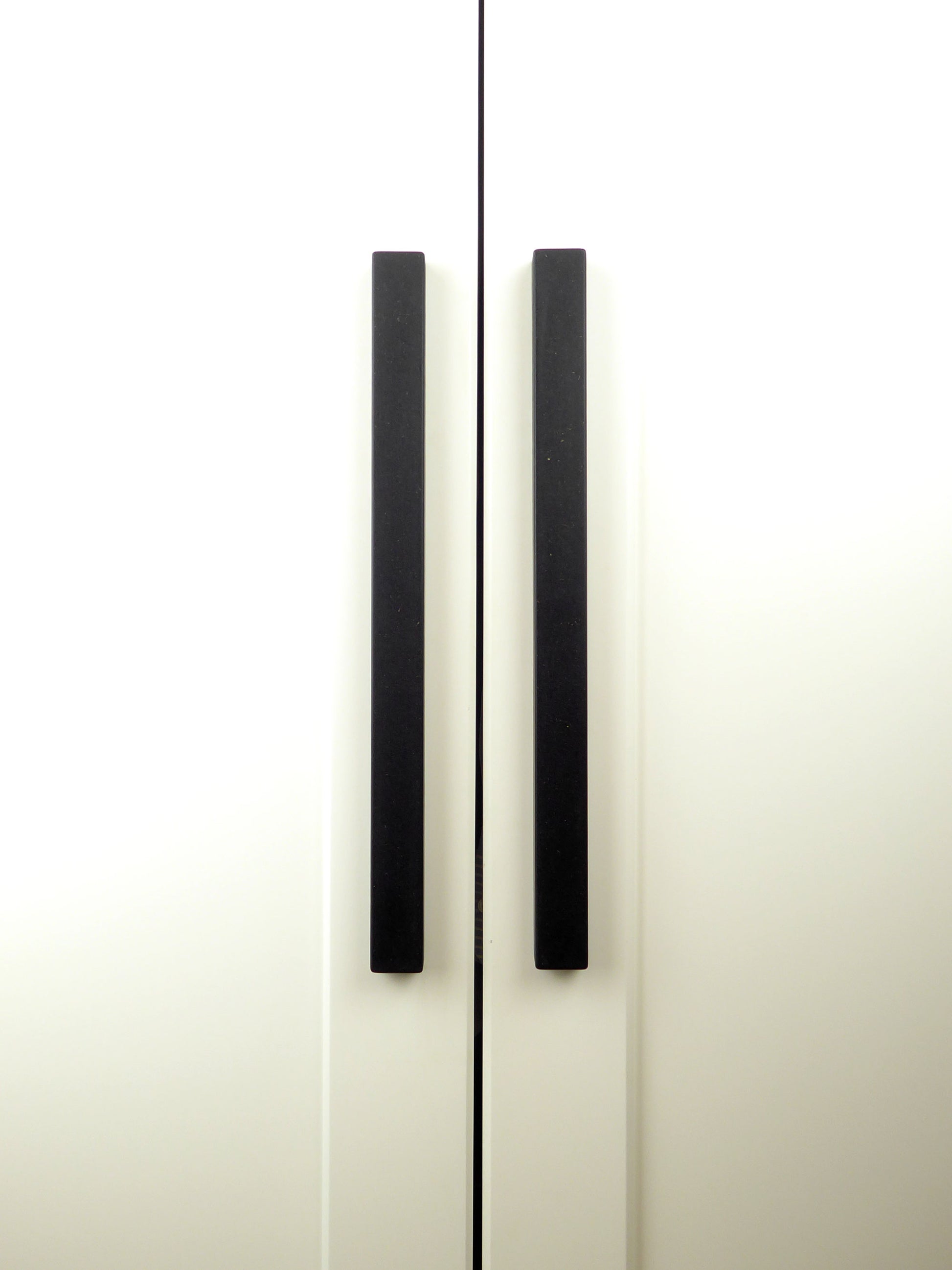 Pair of long black cupboard handles mounted on a kitchen cabinet