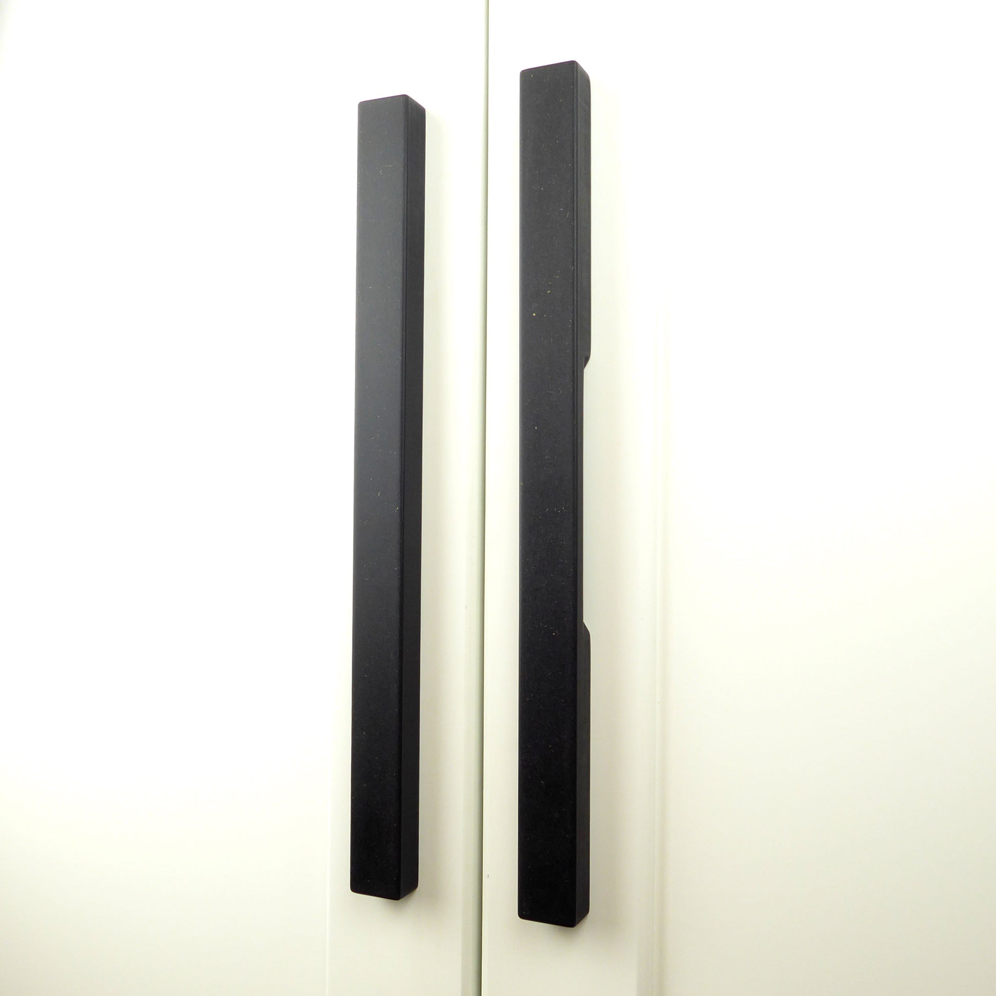 Black wooden pull handles mounted on a wardrobe