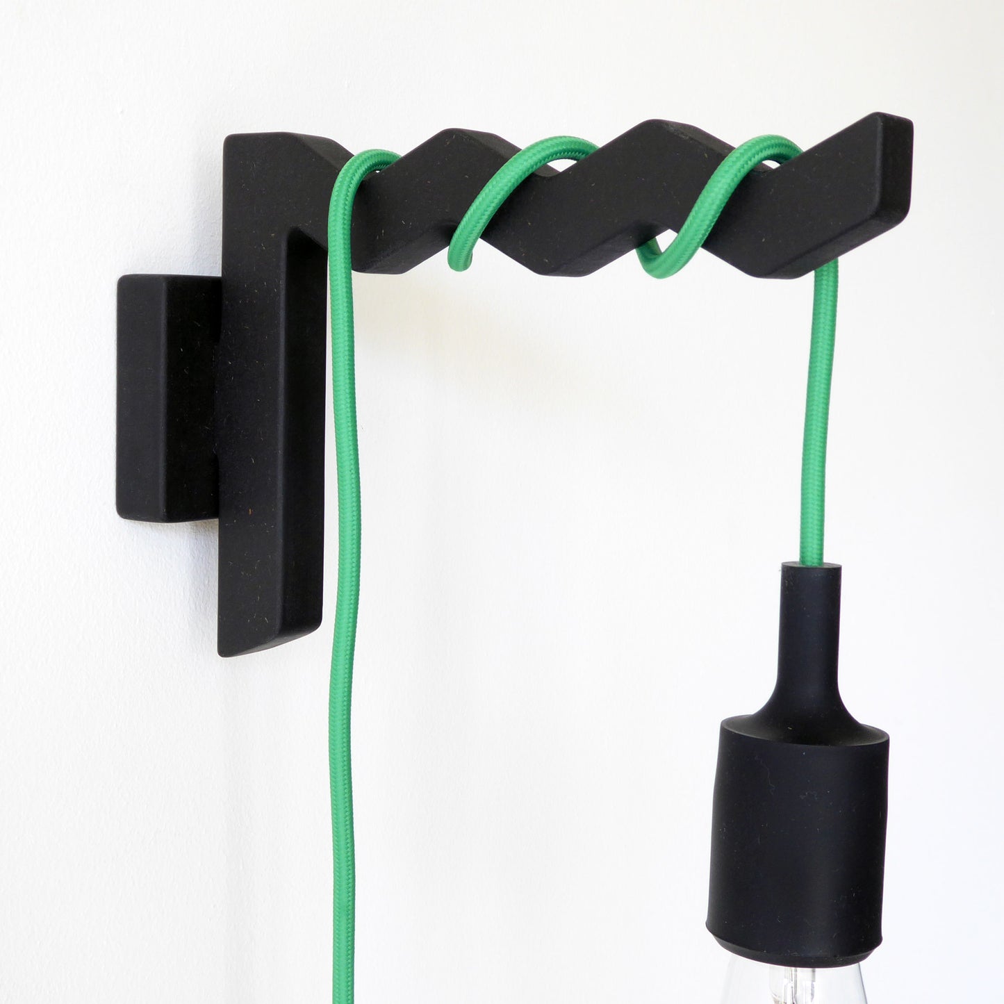 black wooden wall bracket with a plug in pendant lamp wrapped around the arm