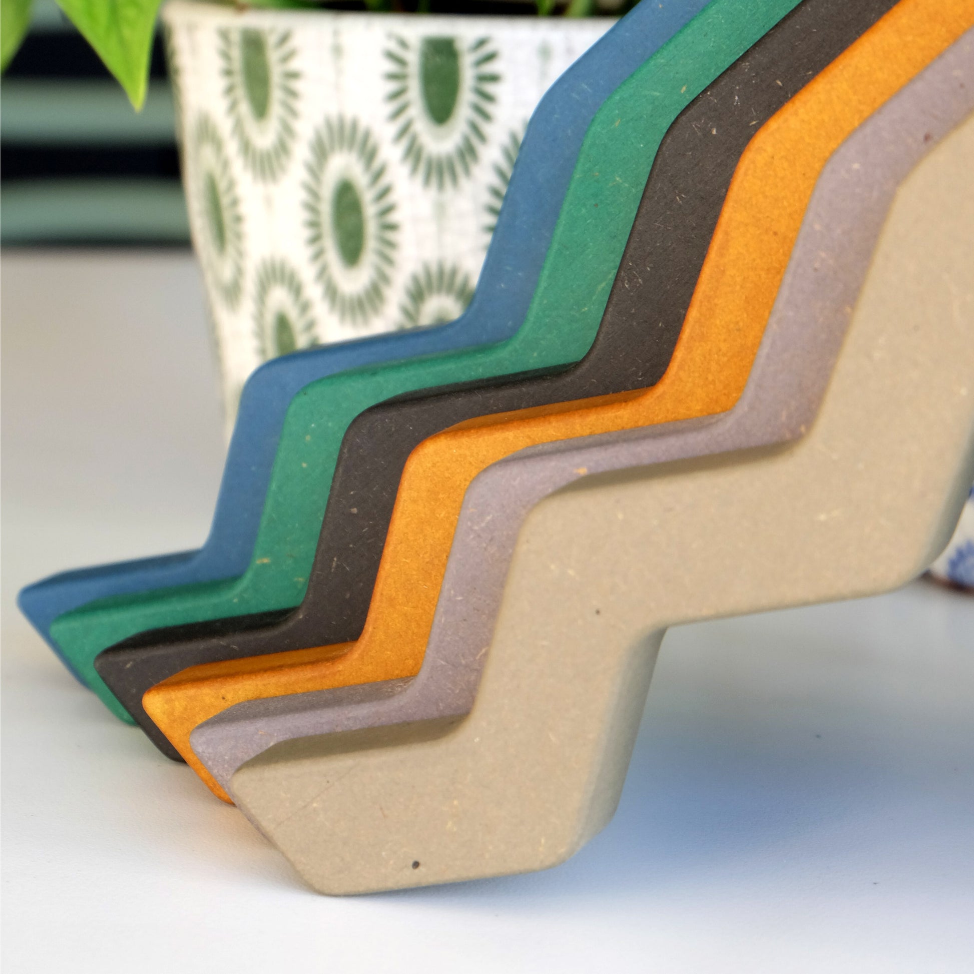 Wood colours for the plant bracket - yellow, blue, green, black, sage and grey - next to a colourful plant pot