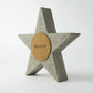 Concrete star-shaped ornament with a cork back with 'SARUS' logo on a white background