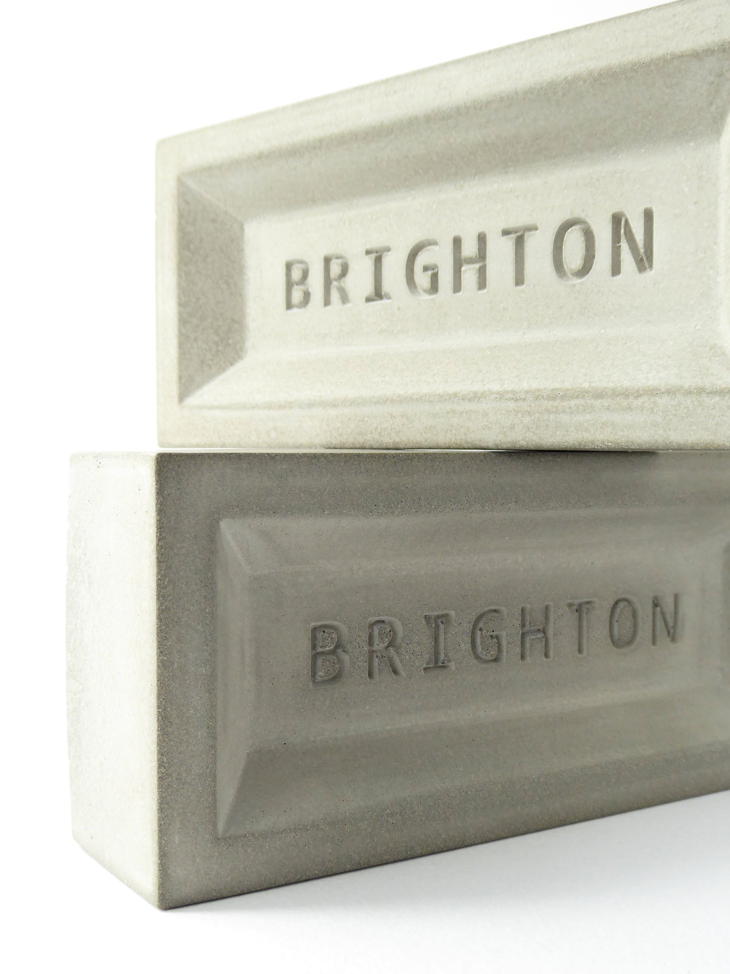 Two concrete brick-like objects with 'BRIGHTON' embossed on them