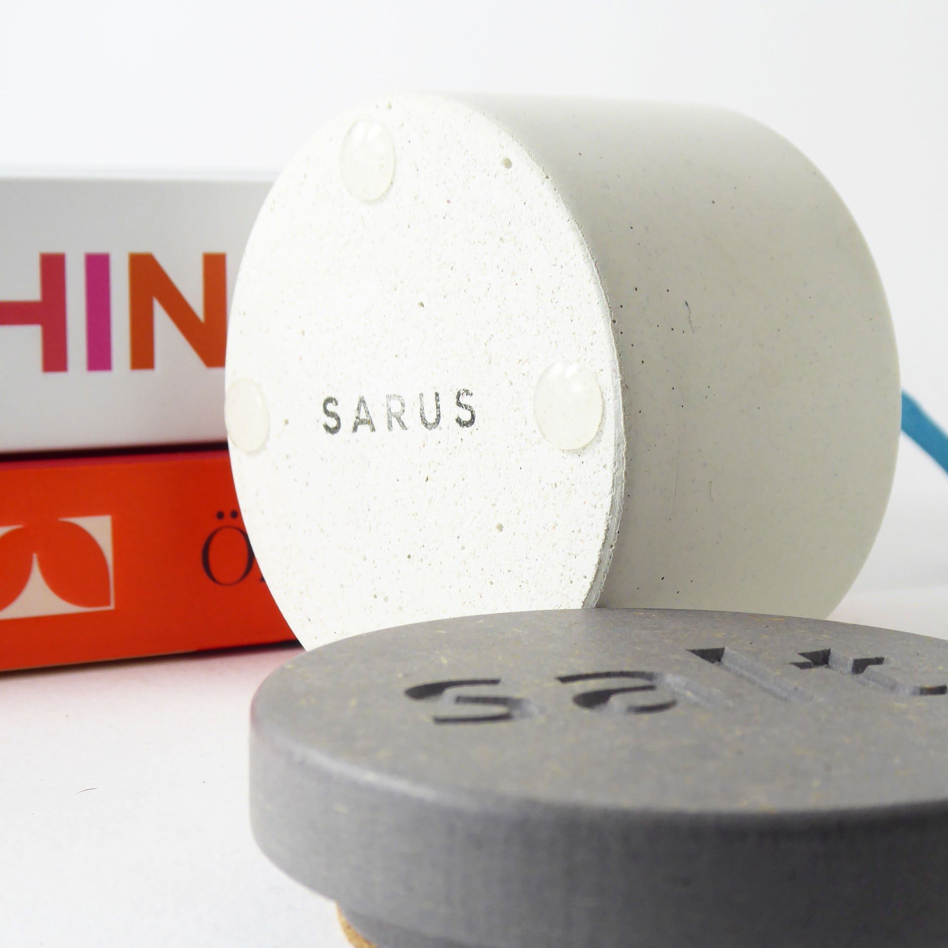 The bottom of a concrete salt pot with the logo 'SARUS' showing the rubber feet