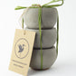 Stack of 3 concrete tea light holders tied with a green ribbon on a white background