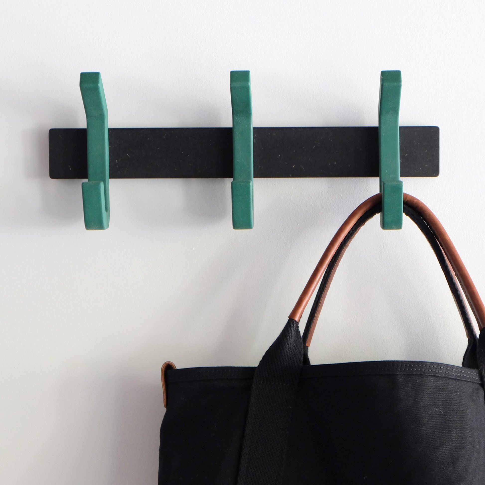 dark green wooden coat rack with matt black wall bracket