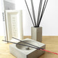 Concrete incense holder with black incense sticks on a shelf with a concrete pot holding incense sticks