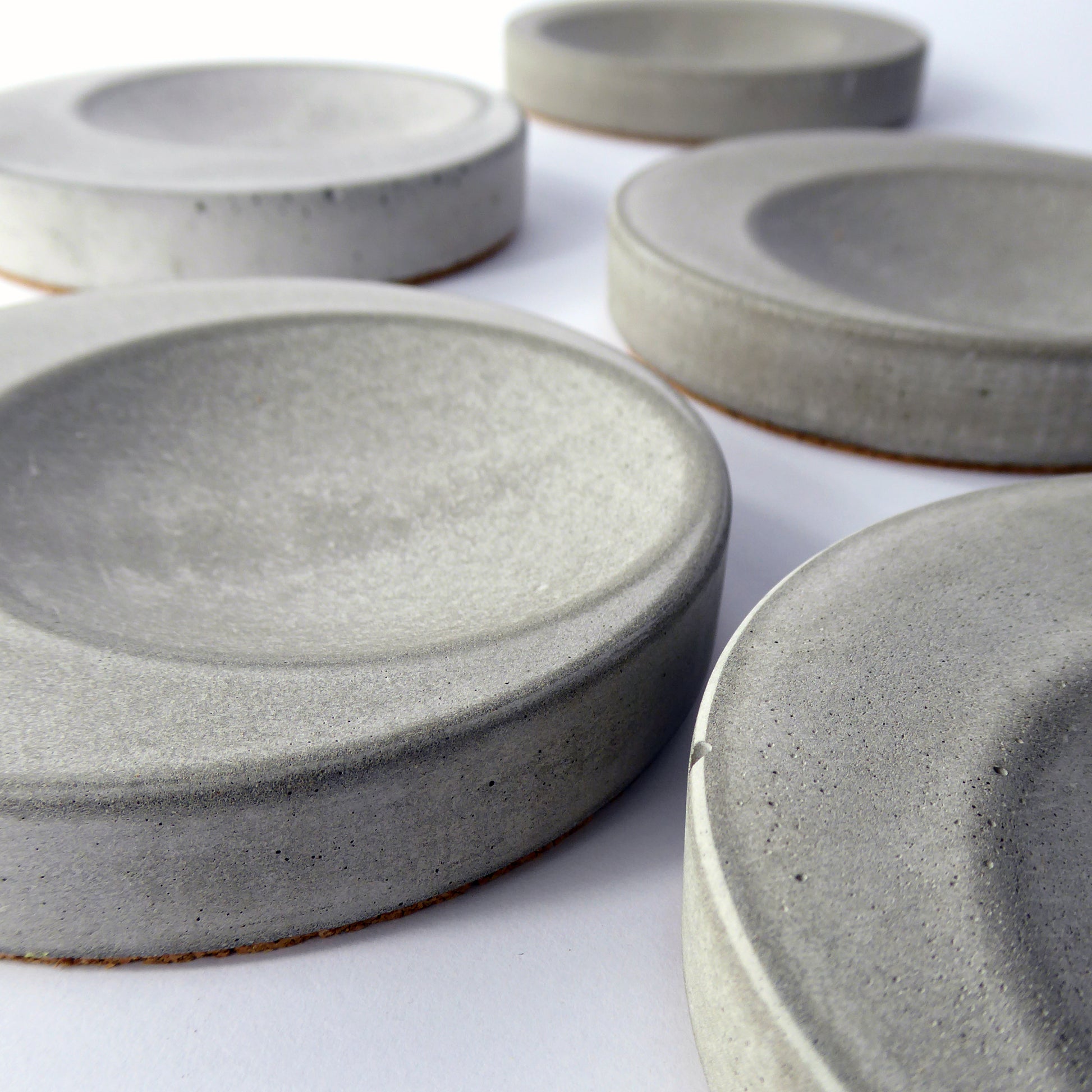 Set of grey concrete round decorative trays showing the texture of hand poured authentic concrete