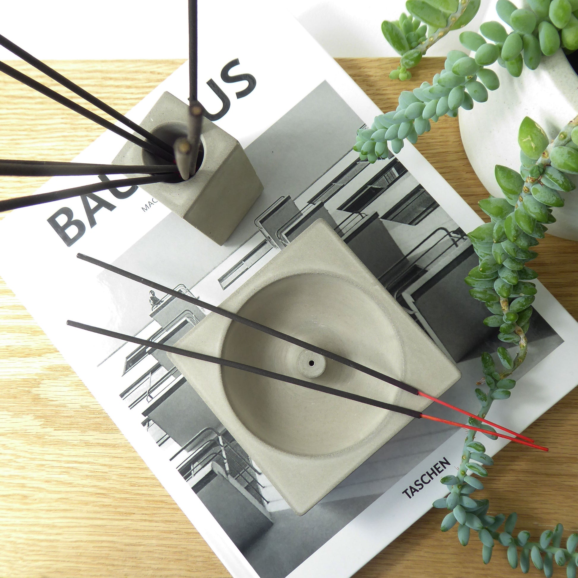 Grey concrete incense holder and a matching pot holding incense sticks