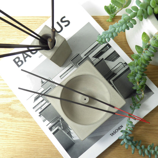Grey concrete incense holder and a matching pot holding incense sticks