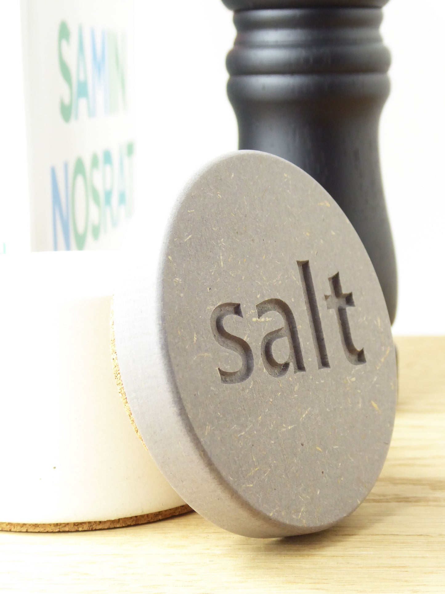 Close-up of an engraved grey wooden lid of a concrete salt pot showing the word 'salt'