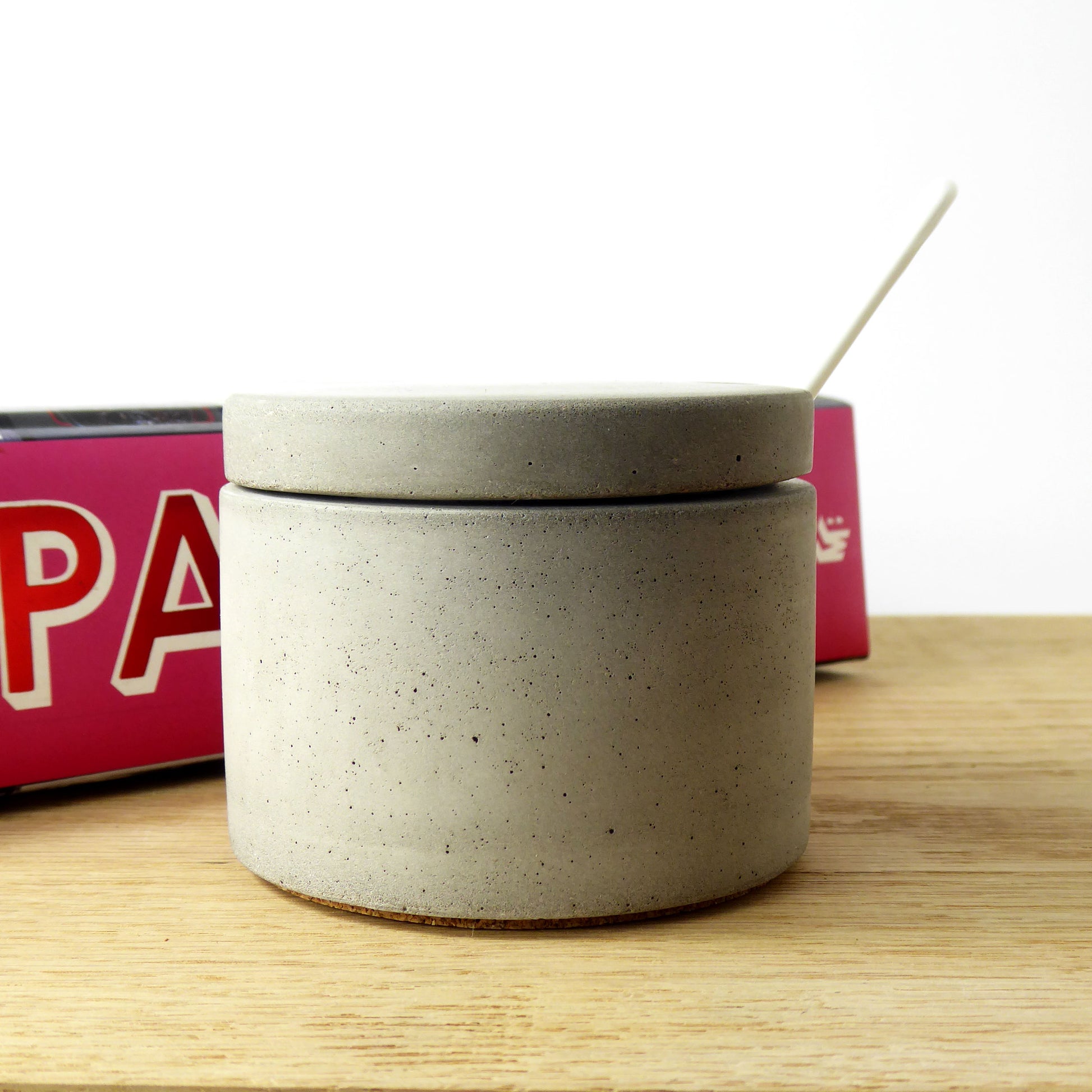 raw concrete pot with lid and white spoon a kitchen worktop with cookbooks