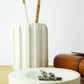 White concrete desk accessories and a leather notebook on a wooden desk
