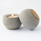 grey concrete candle holder with a lit candle on a white background