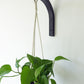 Hanging wooden plant bracket with a houseplant plant mounted on a wall