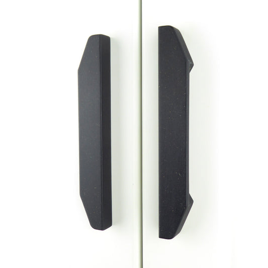 A pair of matt black long wardrobe handles crafted from eco-friendly Valchromat wood