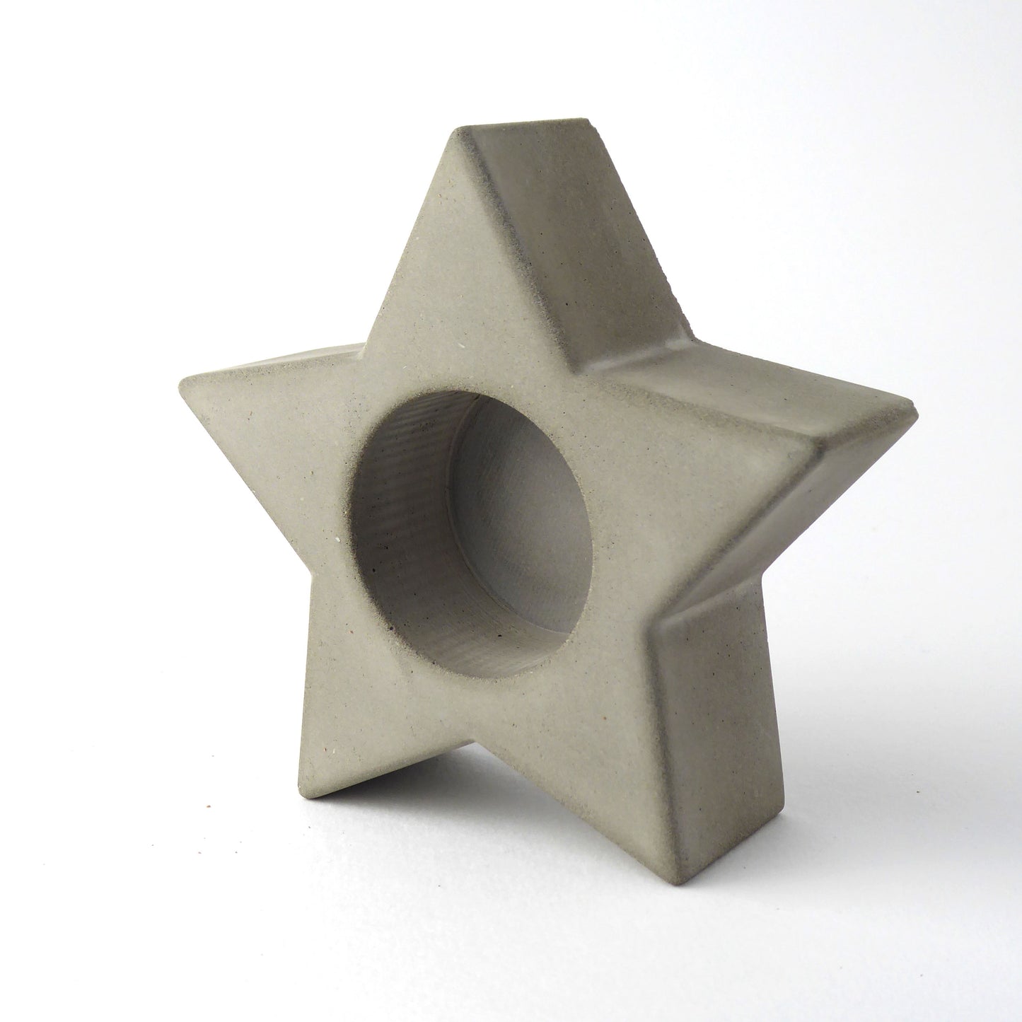 grey concrete star-shaped candle holder on a white background
