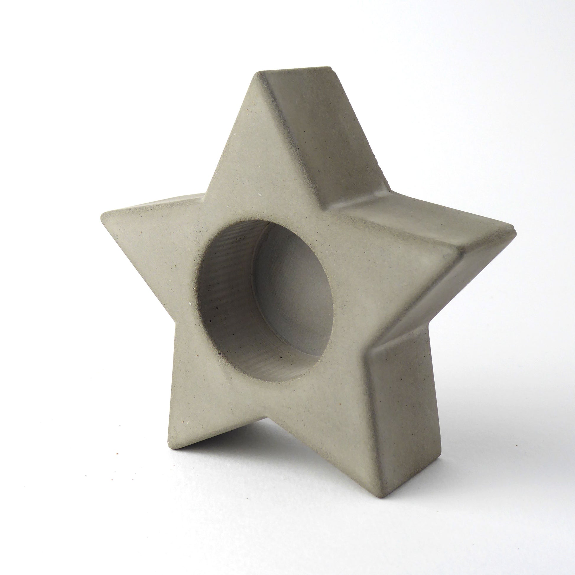 grey concrete star-shaped candle holder on a white background
