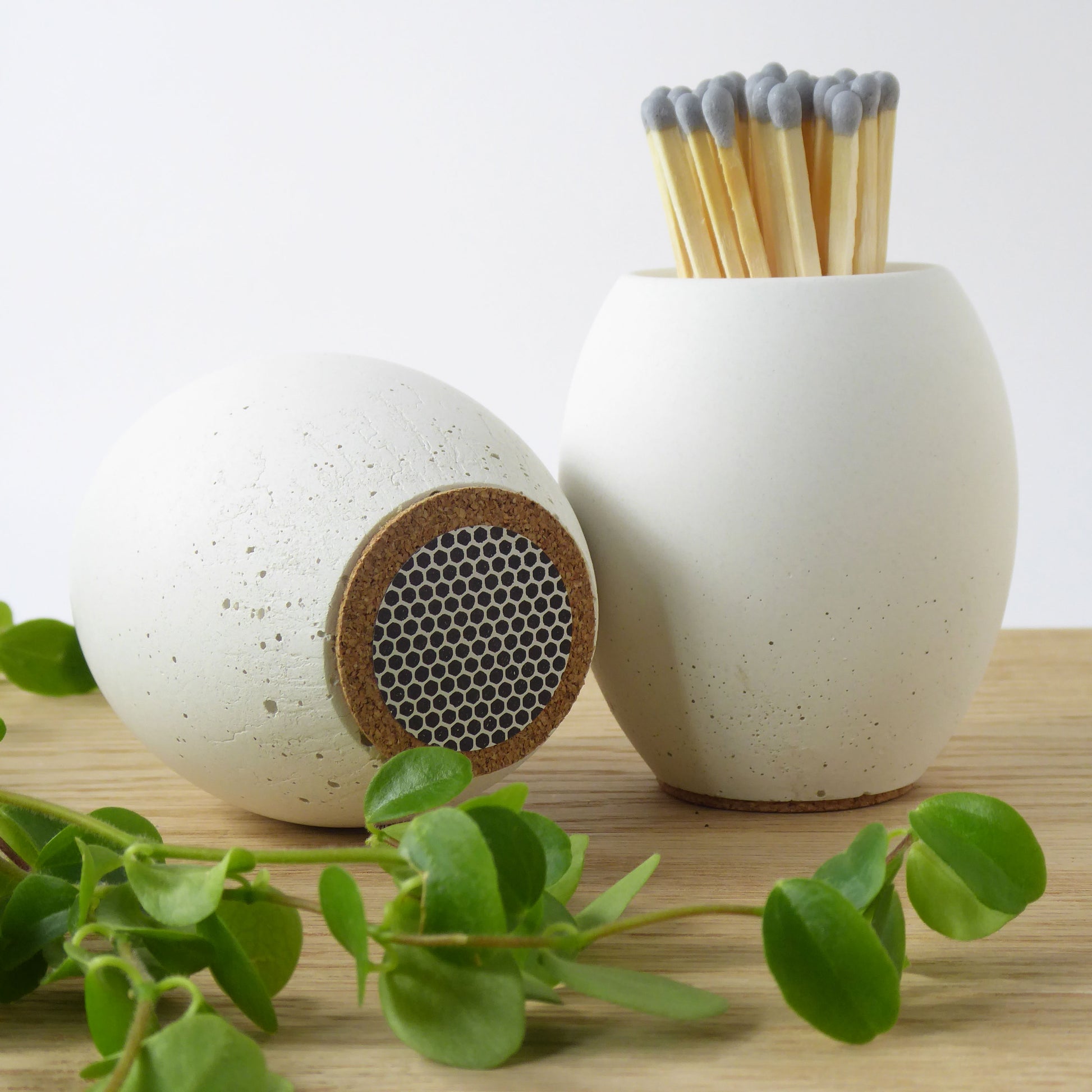 White concrete match pot and another pot showing the striker pad on the bottom for lighting long matches