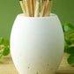 White concrete match pot with long matches on a green background